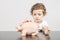 Child inserting coins in a piggy bank