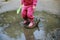 Child jumps in a dirty puddle