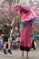 A child jumps to give a high-five to a stilt walker