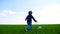 A child kicks a soccer ball and runs on a green grass field in slow motion