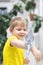 Child kid boy in bright yellow T-shirt laughs and rejoices sitting on his hand gray huge big domestic cockatoo parrot.