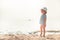 Child kid girl on beach looking into the distance searching for something with bright sunlight concept happy childhood lifestyle