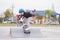 Child or kid girl playing surfskate or skateboard in skating rink or sports park at parking to wearing safety helmet elbow pads