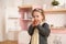 Child in kitchen concept. Adorable hungry toddler girl eating cake in designer play kitchen