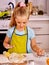 Child knead dough at kitchen