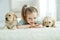 Child with labrador puppies at home on the carpet.