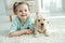 Child with labrador puppies at home on the carpet.