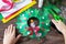 The child is laying the details of the Christmas wreath with a candle. Made by own hands.