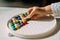 A child lays out a multi-colored mosaic figure with his hand