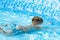 Child learn to swim, dive in blue pool with fun - jumping deep down underwater with splashes