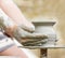 Child learning how to make a pot, old potter h