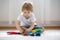 Child learning how to put in pairs different socks, kid sitting on the floor and playing with socks