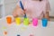 The child learns colors. A little girl sorts the animal figures by color throwing them into the appropriate cup.