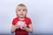 Child learns to save money. little boy with blond hair holding piggy Bank