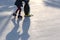 A child learns to skate on a skating ice rink at sunset and holds on to a plastic penguin for support. Fun winter time