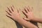 Child leaving handprints on sand outdoors, closeup. Fleeting time concept