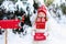 Child with letter to Santa at Christmas mail box in snow