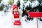 Child with letter to Santa at Christmas mail box in snow