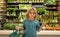 Child with lettuce salad. Kid in a food store or a supermarket. Little kid going shopping. Healthy food for kids.