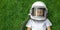 child lies on the grass wearing an astronaut`s helmet and dreams of great achievements