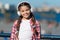 Child listen music outdoors modern headphones. Kid little girl listen song headphones. Music account playlist. Customize