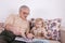 The child listens with delight to his grandfather, who reads him a book