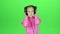 Child listens to the music in the headphones. Green screen