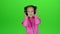 Child listens to the music in the headphones. Green screen. Slow motion