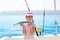 child little girl fishing in boat holding little tunny fish catch