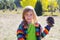 Child little girl holding pine cone in winter fall