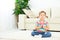 Child little girl meditates in lotus position and practices yoga
