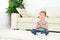 Child little girl meditates in lotus position and practices yoga