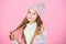 Child long hair smiling. Girl wear knitted hat pink background. Prevent winter hair damage. Winter hair care tips you