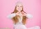 Child long hair smiling show heart gesture. Girl wear knitted hat pink background. Look after scalp and hair this winter