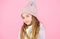 Child long hair warm soft woolen hat enjoy softness. Kid girl wear knitted soft hat pink background. Keep knitwear soft