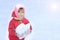 A child looks into the camera, snow, in his hands a snowball, against a background of white snow