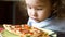 Child looks at pizza on table. Three years old kid is going to eat by himself