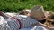 Child lying on blanket having picnic in summer park. Girl spread her arms out to the sides, her face covered with a