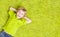 Child Lying Over Green Carpet. Happy Smiling Kid Boy
