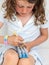 Child making a bracelet on a band loom