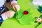 Child making felt soft toy of green leaf and red ladybag . Child DIY activity. Close-up. Children handicraft concept