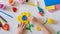 Child making homemade greeting card. little girl making flower from clay, plasticine as gift for Mothers day, Birthday or Valentin