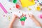 Child making homemade greeting card. little girl making vase with flowers from paper and clay, plasticine as gift for Mothers day