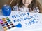 Child making homemade greeting card. A little girl paints a heart on a homemade greeting card as a gift for Father Day