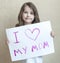 Child making homemade greeting card. A little girl paints a heart on a homemade greeting card as a gift for Mother Day