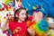 A child and a man in a clown wig lie in confetti on a white background. Celebrate a bright event.