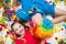 A child and a man in a clown wig lie in confetti on a white background. Celebrate a bright event.