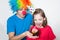 A child and a man in a clown wig will inflate a bright event.