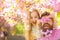 Child and man with tender pink flowers in beard. Girl with dad near sakura flowers on spring day. Father and daughter on