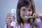 Child measures time while brushes her teeth. Healthy habits, dentalcare concept. Close up